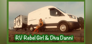A woman sits on the ground beside a white RV, with a small dog, showcasing a nomadic lifestyle amid grassy surroundings.