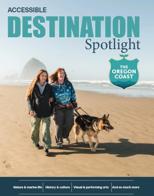 A full-color magazine cover titled "Accessible Destination Spotlight" features two women walking on a sandy beach. One woman is holding the arm of the other, who is walking a German Shepherd service dog on a harness. The two are smiling as they walk. Haystack Rock is visible in the background, and the title "The Oregon Coast" is in a badge in the upper right corner. Below the photo are four headings: "Nature & marine life," "History & culture," "Visual & performing arts," and "And so much more.