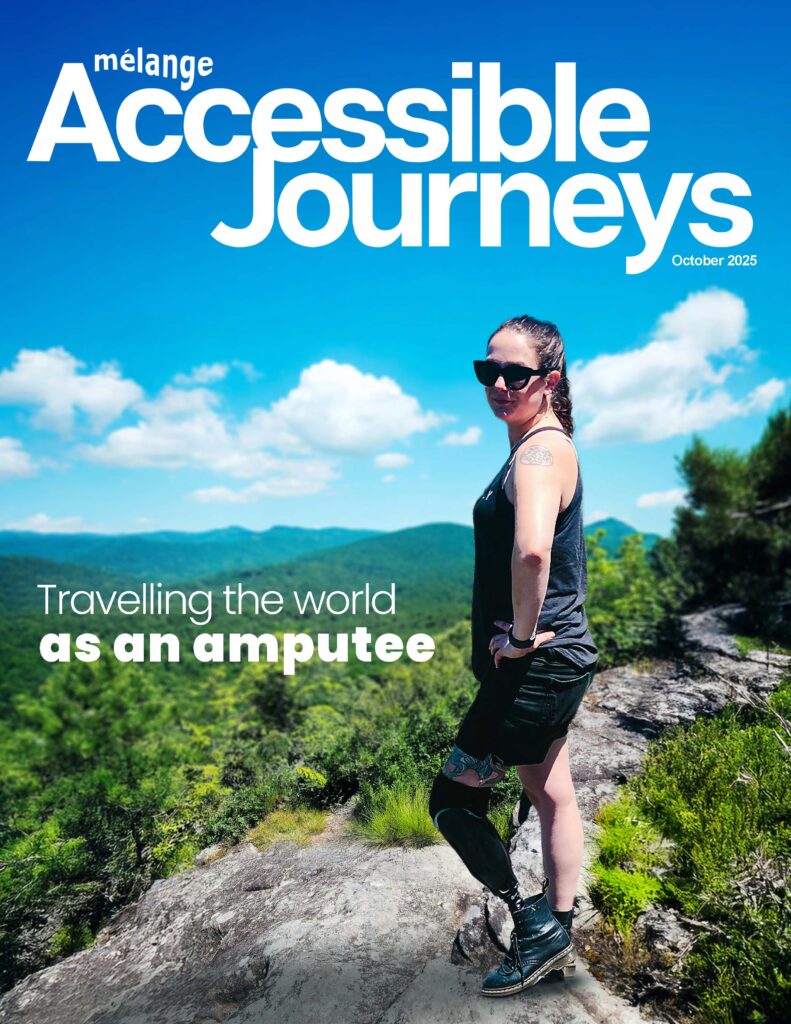 Woman with a prosthetic leg standing confidently on a mountain trail, featured on the cover of Accessible Journeys magazine, October 2025 issue, highlighting travelling the world as an amputee.
