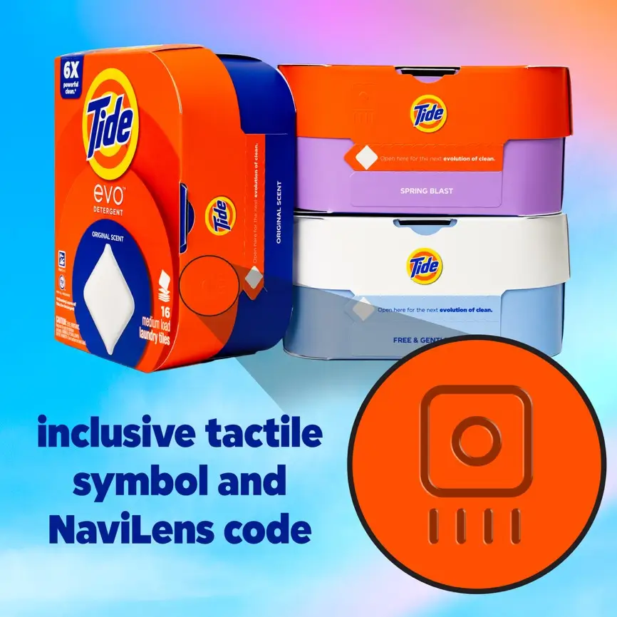 A group of Tide Evo laundry detergent tile boxes in orange, purple, and blue. An orange circular graphic in the foreground highlights "inclusive tactile symbol and NaviLens code," showcasing the accessible design features on the detergent packaging.