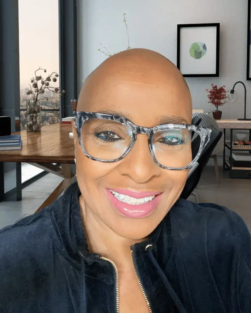 Close-up portrait of Mary Johnson wearing glittery grey eyeglasses in a modern home office.