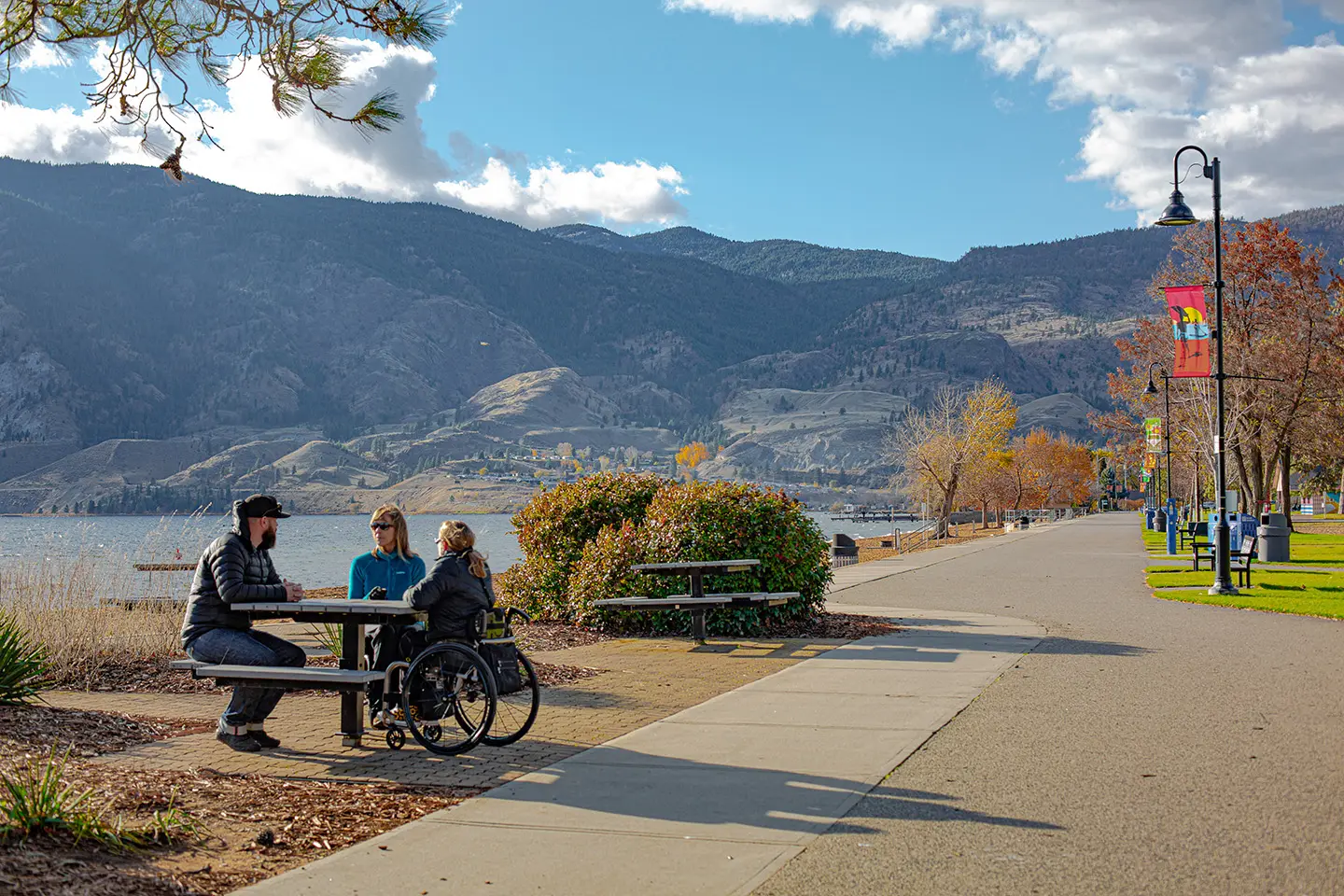 Friends at a picnic table beside Skaha Lake